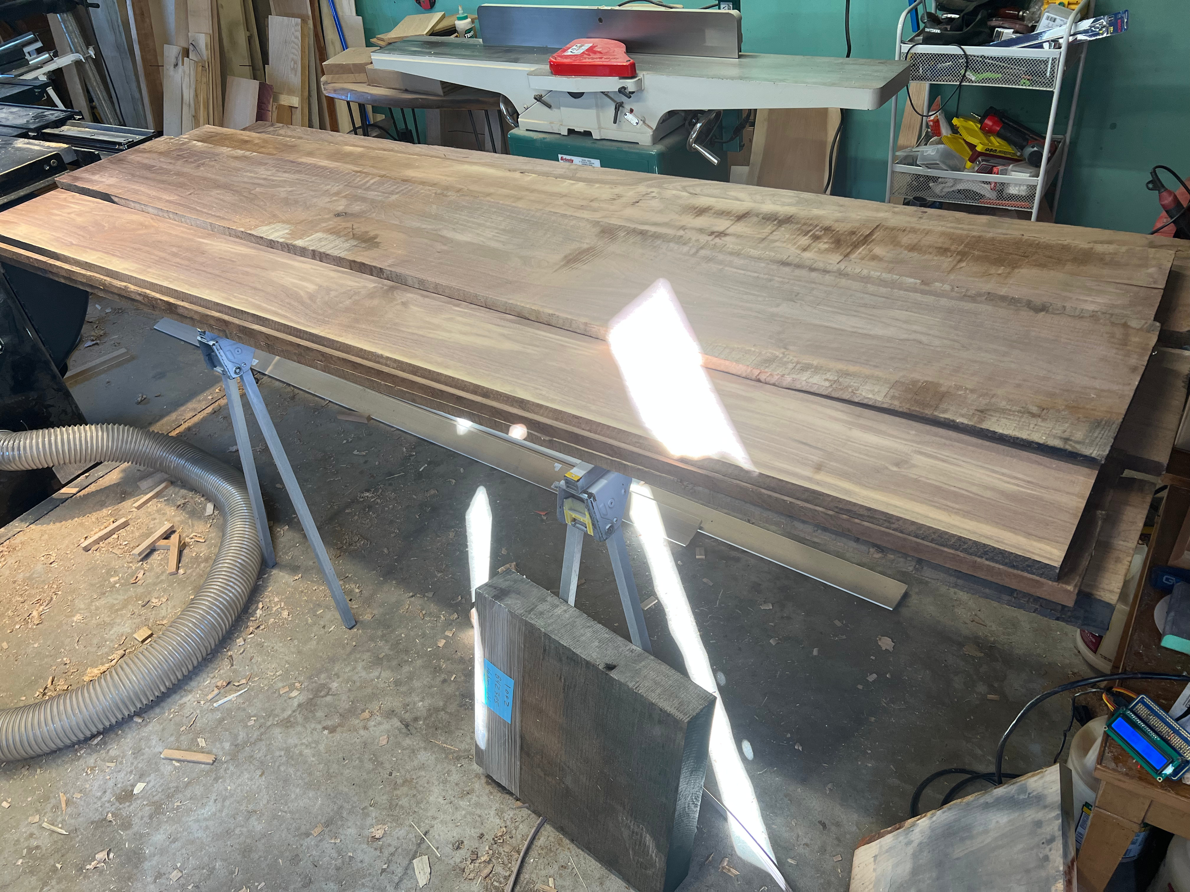 Rough walnut boards laid out in the shop